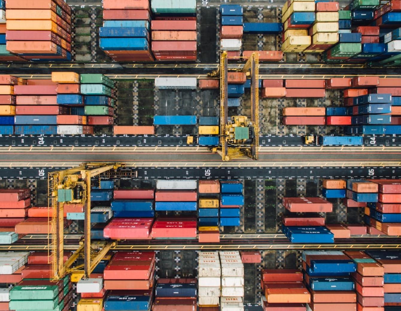 Birds-eye view of a cargo ship with multiple cargo shipments in red and blue colors.
